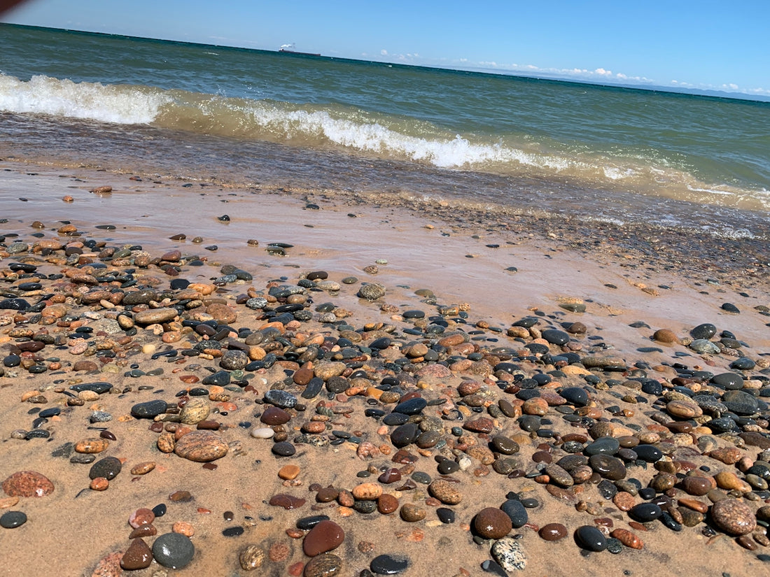 a beach covered in lots of rocks next to the ocean