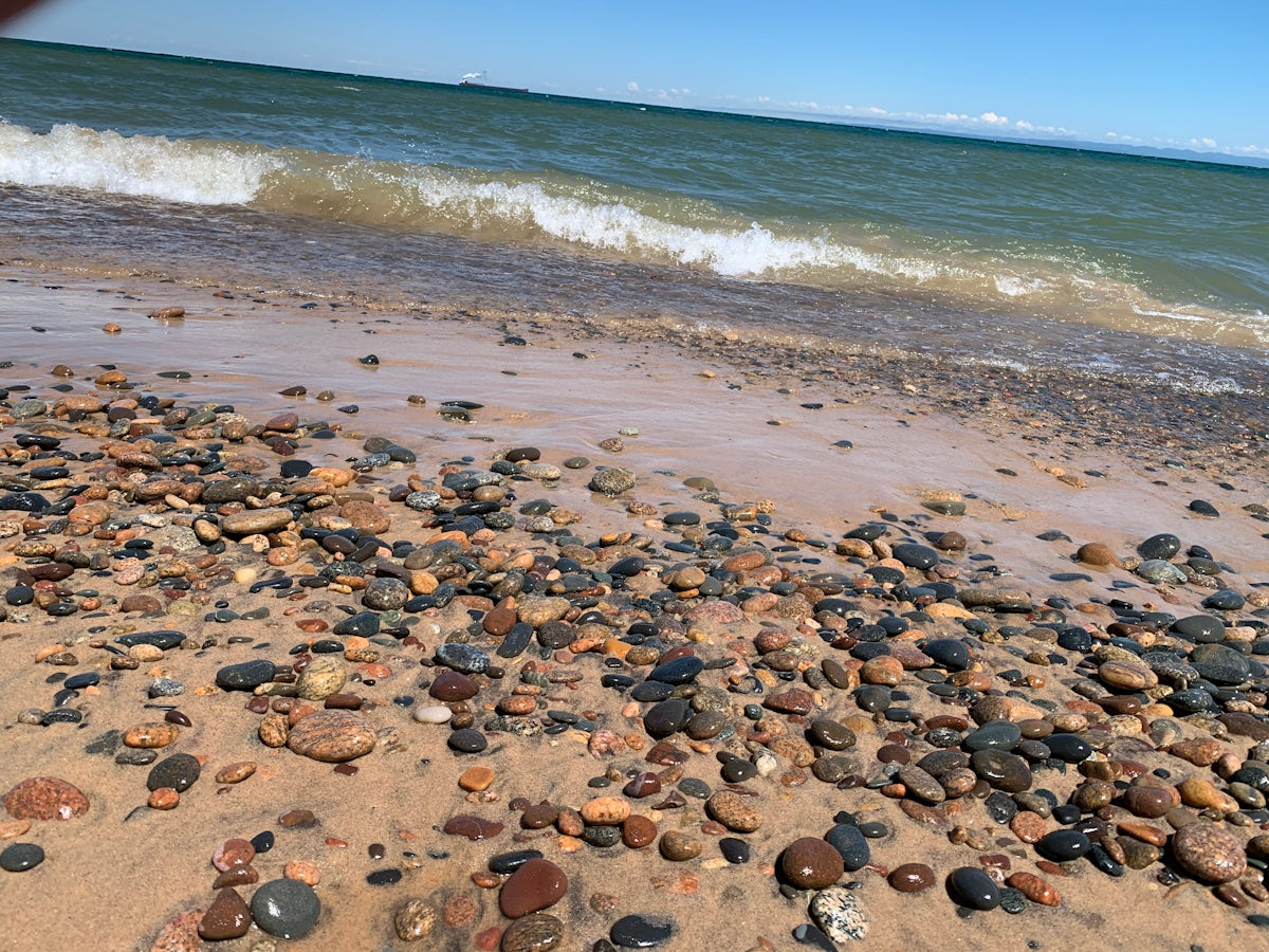 a beach covered in lots of rocks next to the ocean