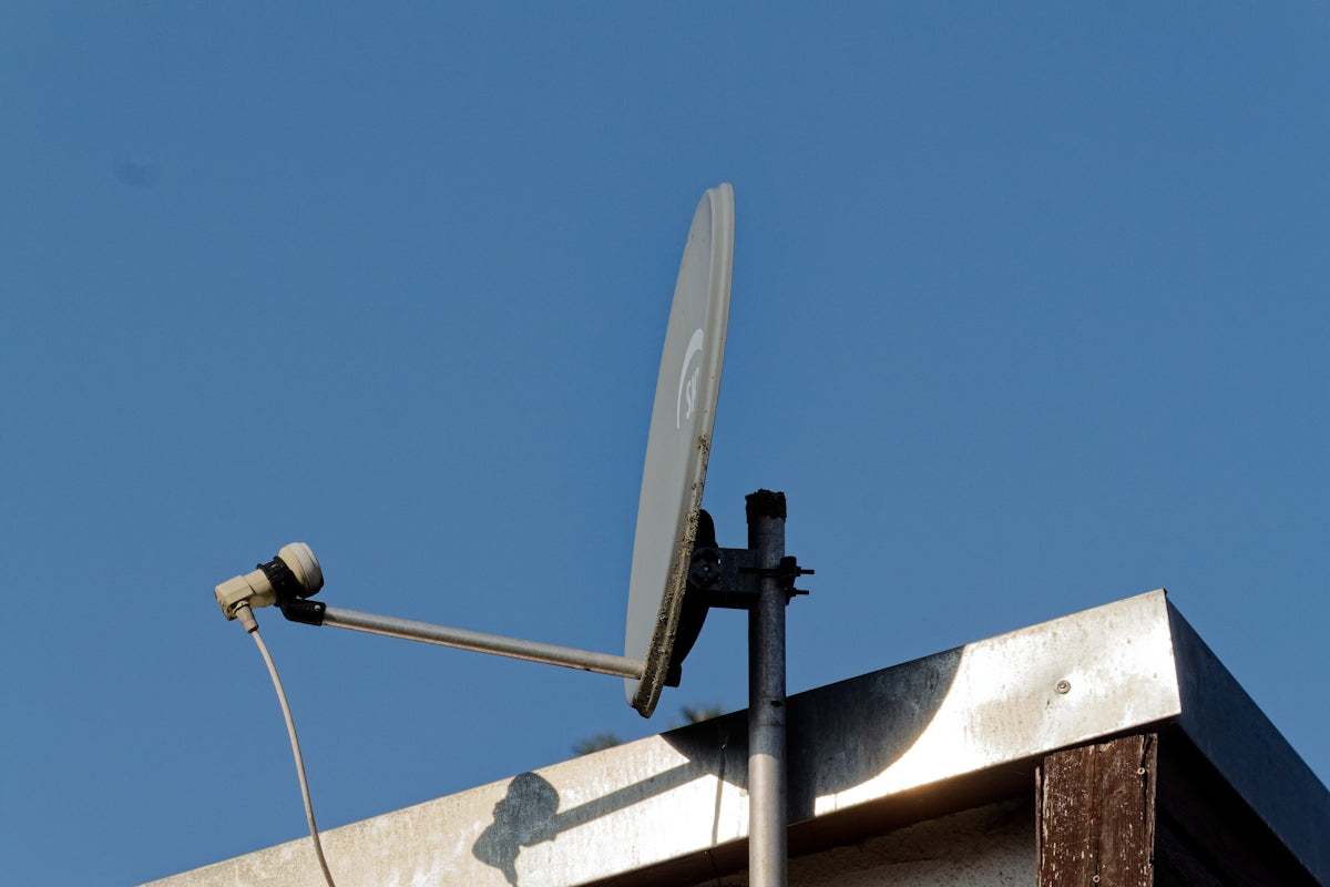 a satellite dish mounted to the side of a building