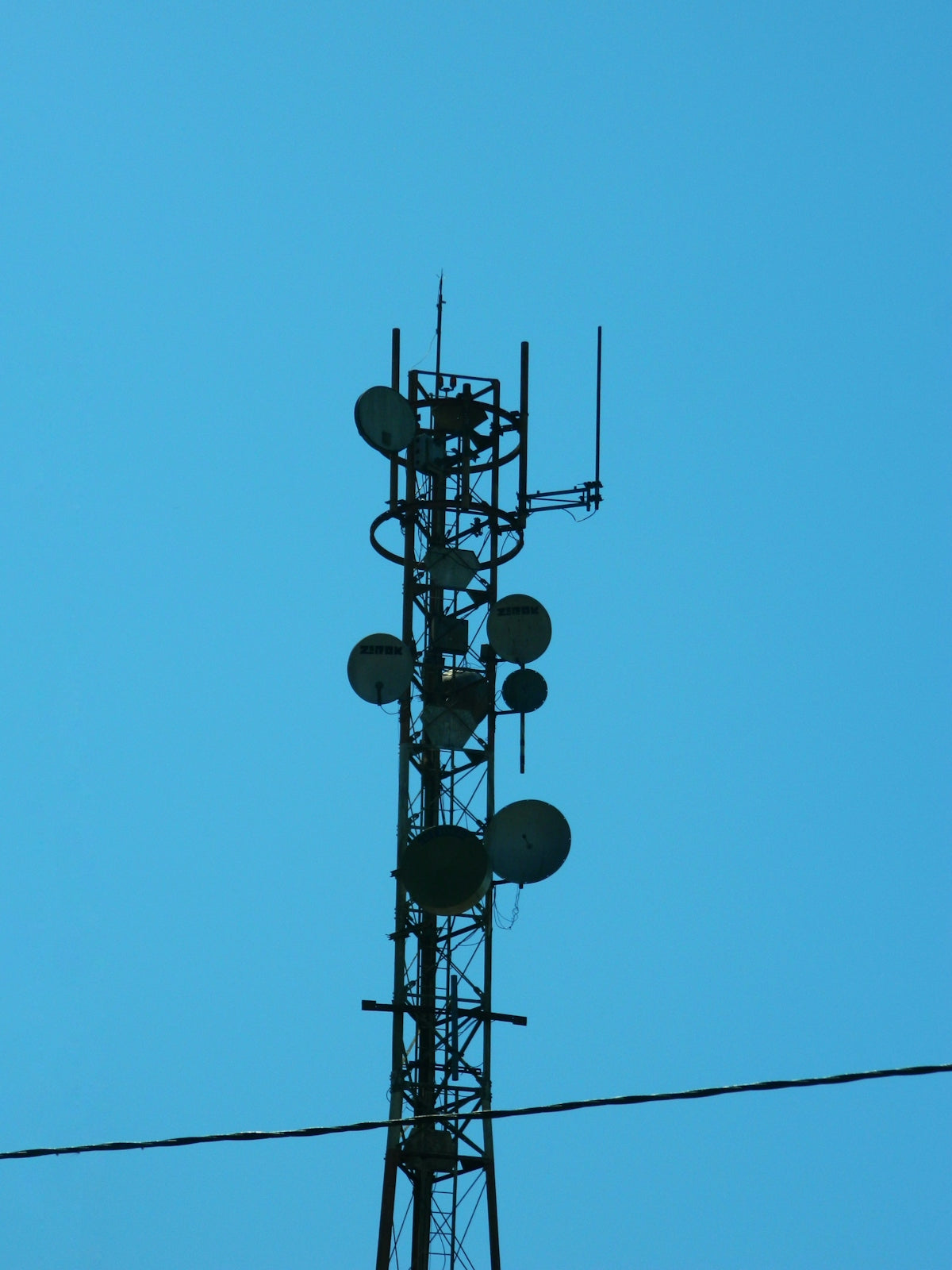 A tall tower with a lot of antennas on top of it