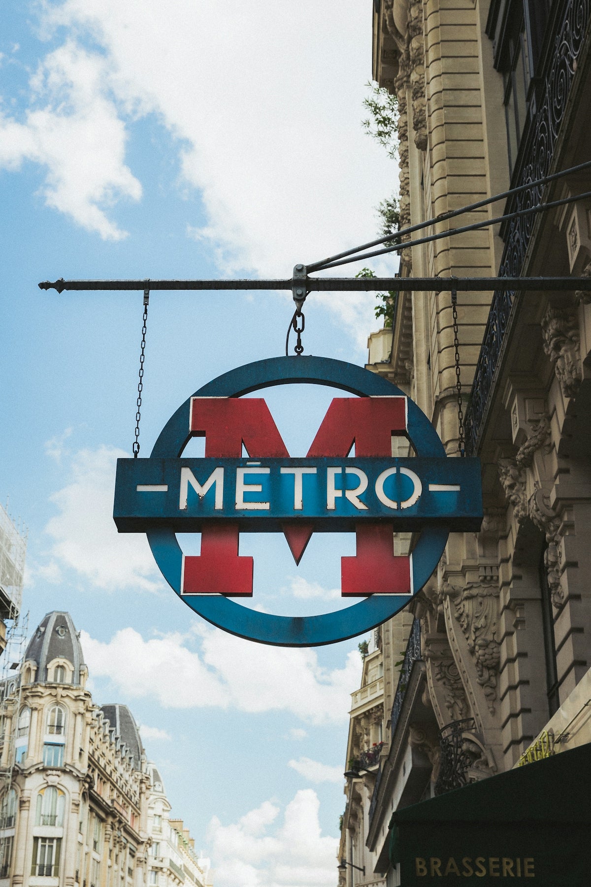 Paris metro sign hanging on a building